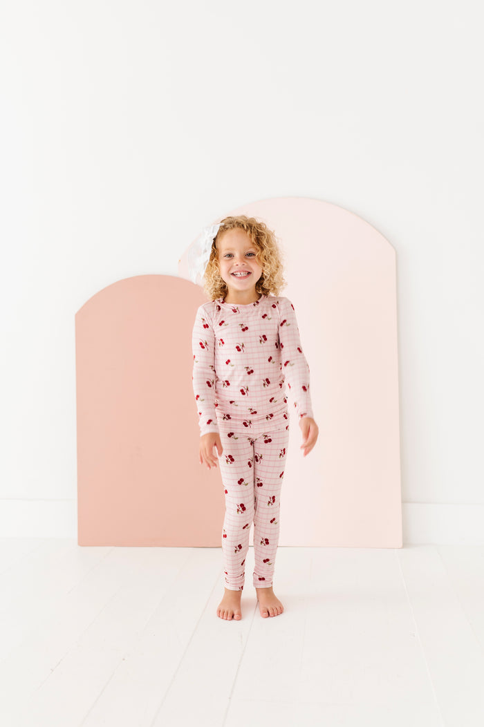 Child wearing a patterned pajama set against a white background