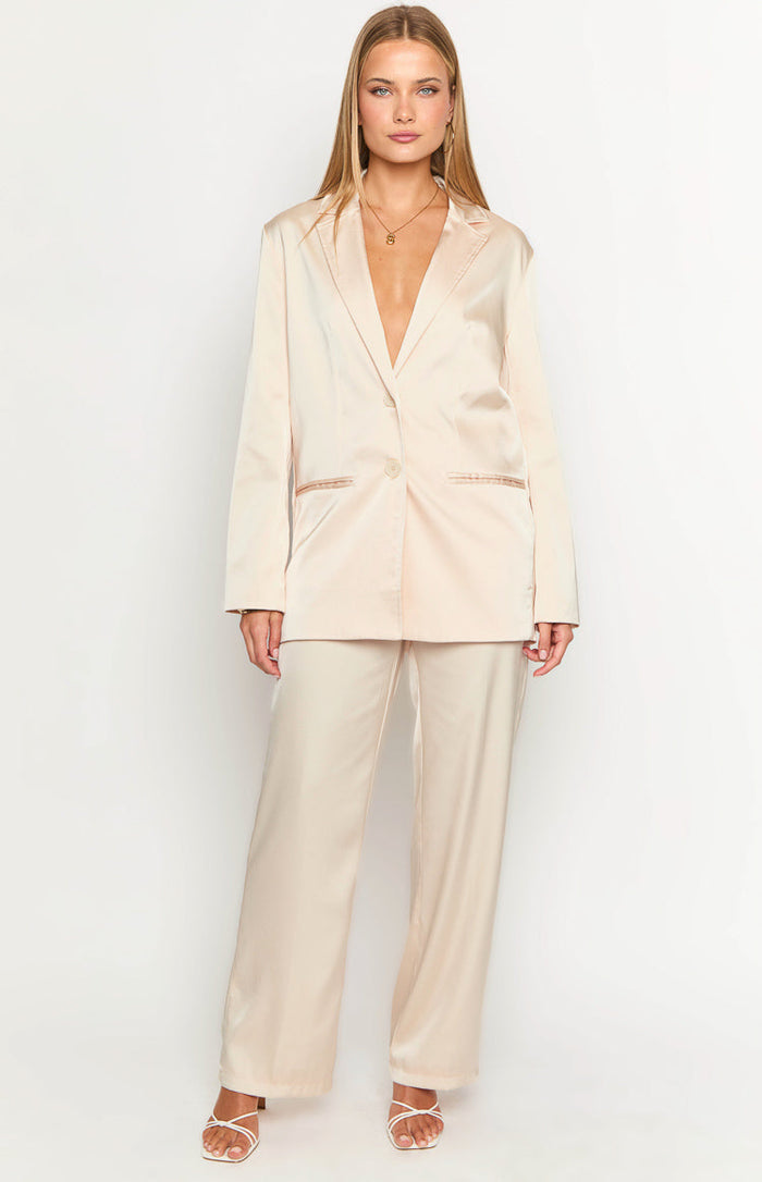 Full length view of a cream satin blazer featuring notched lapels and a single button, with matching wide-leg pants