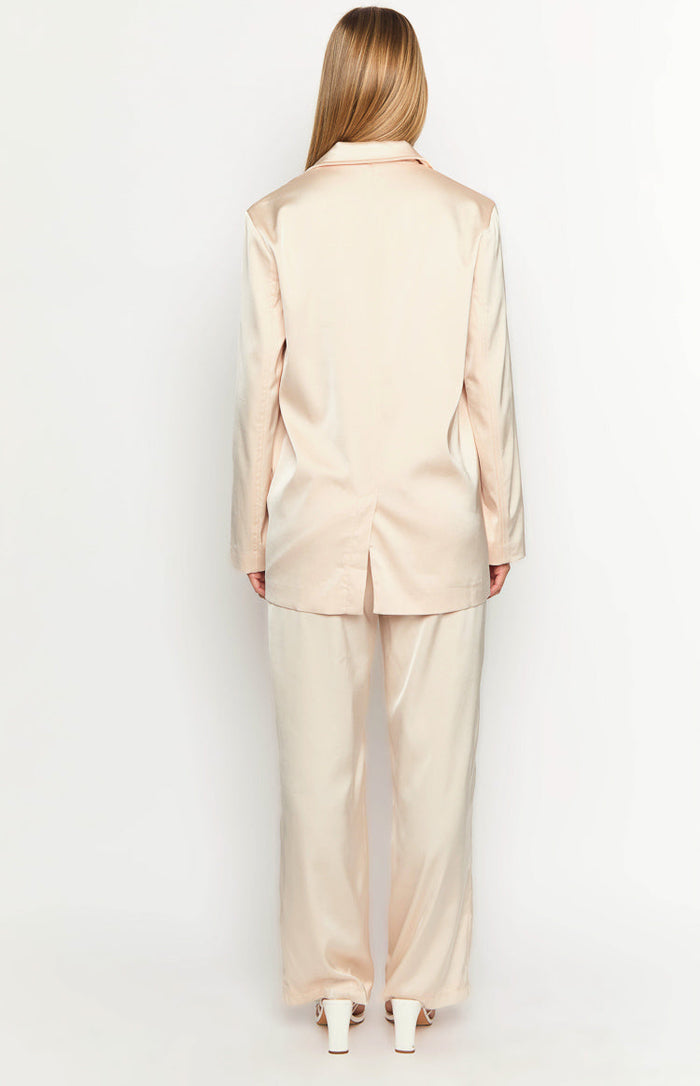 Back view of a cream satin blazer with a collar, long sleeves, and a single vent at the hem
